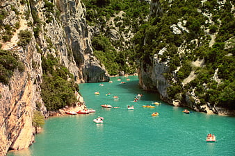 Turquoise river canyon with people rafting and kayaking