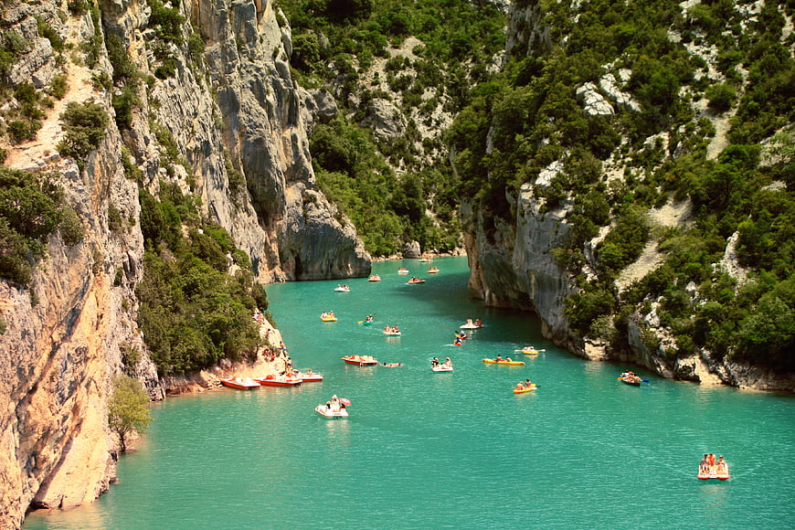Turquoise river canyon with people rafting and kayaking
