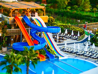 Tilt-shift water park with colorful slides and pool