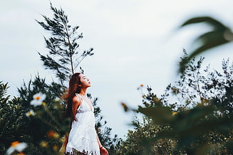 Asian woman in white dress enjoying nature outdoors