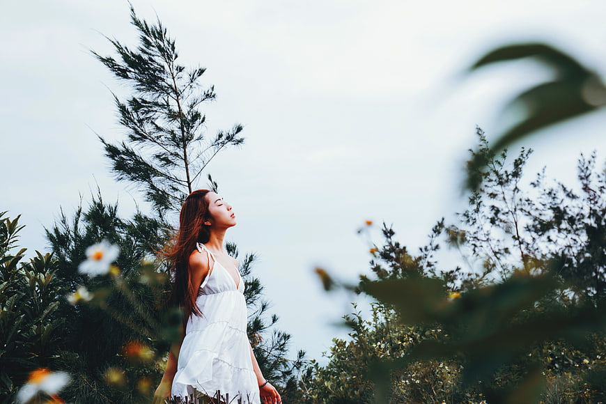 Asian woman in white dress enjoying nature outdoors