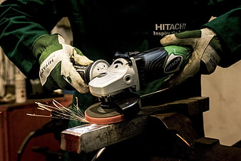 Worker grinding metal with angle grinder sparks