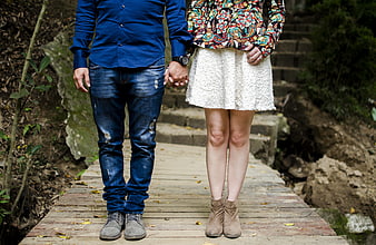Couple Holding Hands on Wooden Bridge in Nature
