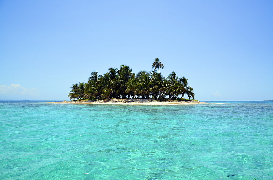 Tropical island with palm trees in turquoise ocean water