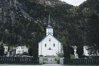 White wooden church with steeple in mountain village