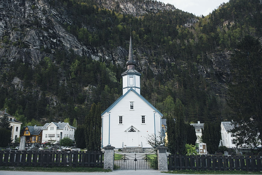 White wooden church with steeple in mountain village