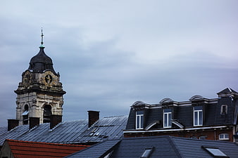 Historic clock tower rising above European city rooftops