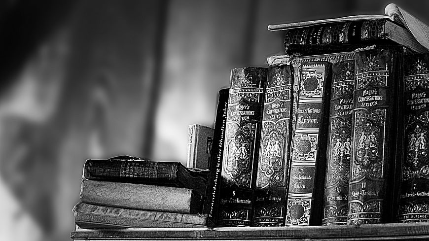 Vintage Antique Books Stacked on Shelf in Black and White