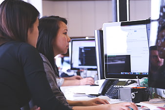 Two women working at computers in a modern office