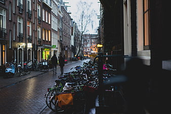 Bicycles parked on a wet cobblestone street in Amsterdam