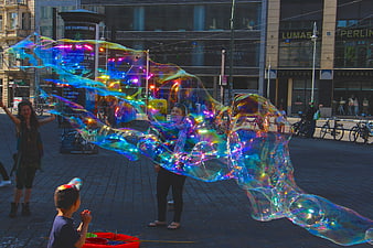 Giant iridescent soap bubbles in Berlin city square