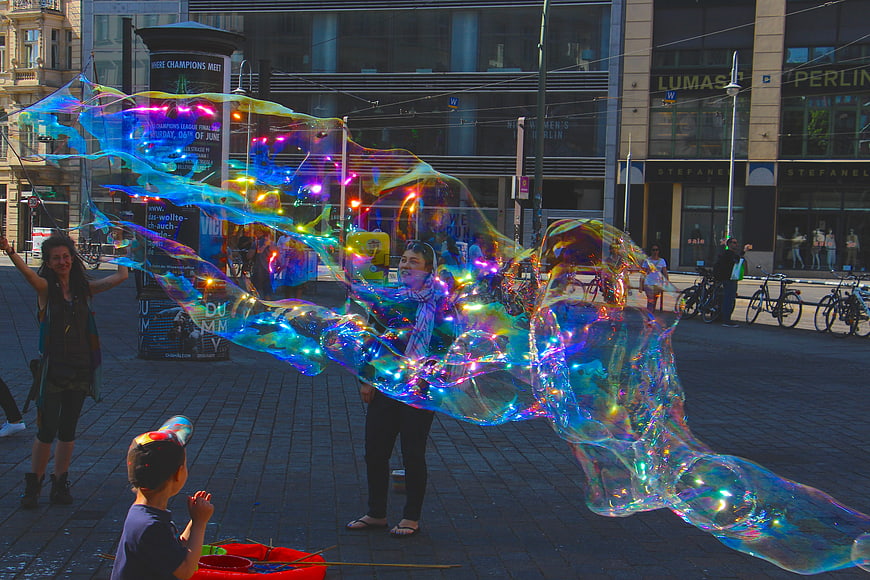 Giant iridescent soap bubbles in Berlin city square