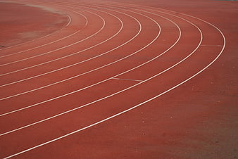 Curved red running track lanes with white lines