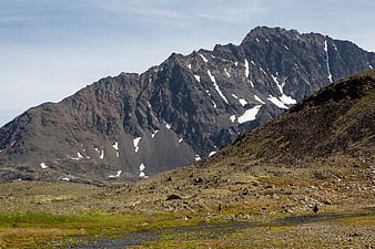 Hikers in Rocky Mountain Landscape with Snow Patches