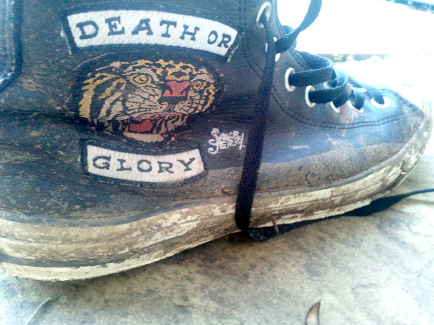 Worn black high-top sneaker with Sailor Jerry tattoo art