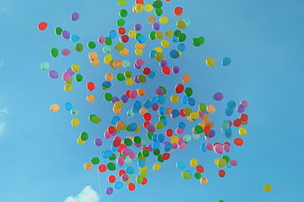Colorful balloons floating in blue sky