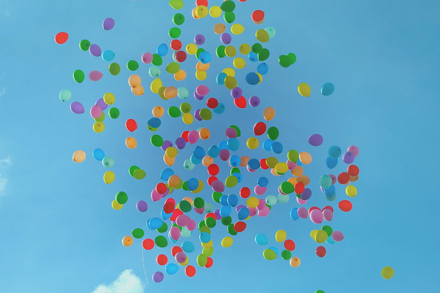 Colorful balloons floating in blue sky