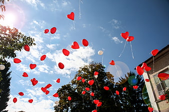 Red Heart Balloons Floating in Blue Sky