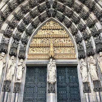 Gothic Cathedral Portal with Intricate Stone Sculptures and Golden Tympanum