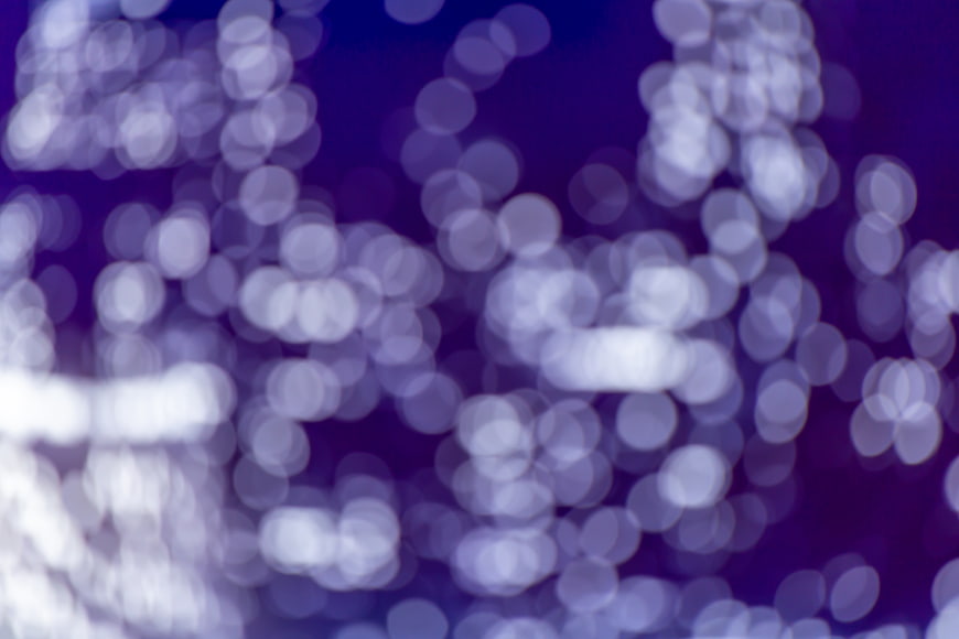 Abstract purple bokeh background with glowing light circles