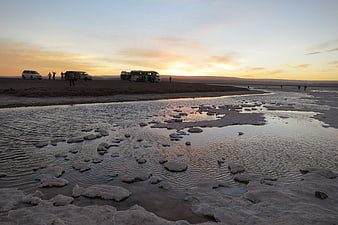 Sunset over Laguna Cejar salt flats with tour buses and tourists