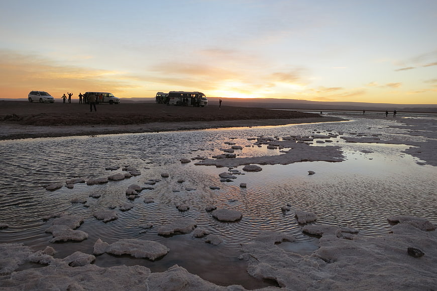 Sunset over Laguna Cejar salt flats with tour buses and tourists