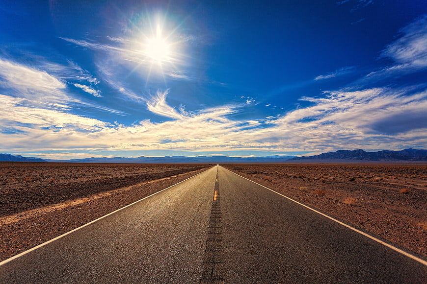 Endless Desert Highway Under Bright Blue Sky
