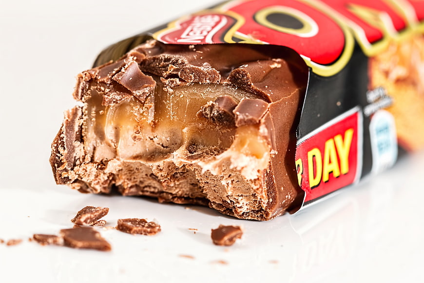 Close-up of bitten chocolate caramel bar with wrapper