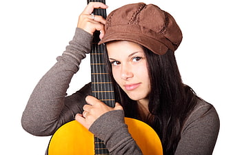 Young woman with acoustic guitar and brown cap