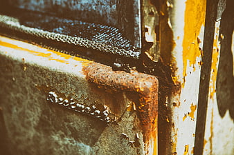 Close-up of rusty metal texture with peeling yellow paint