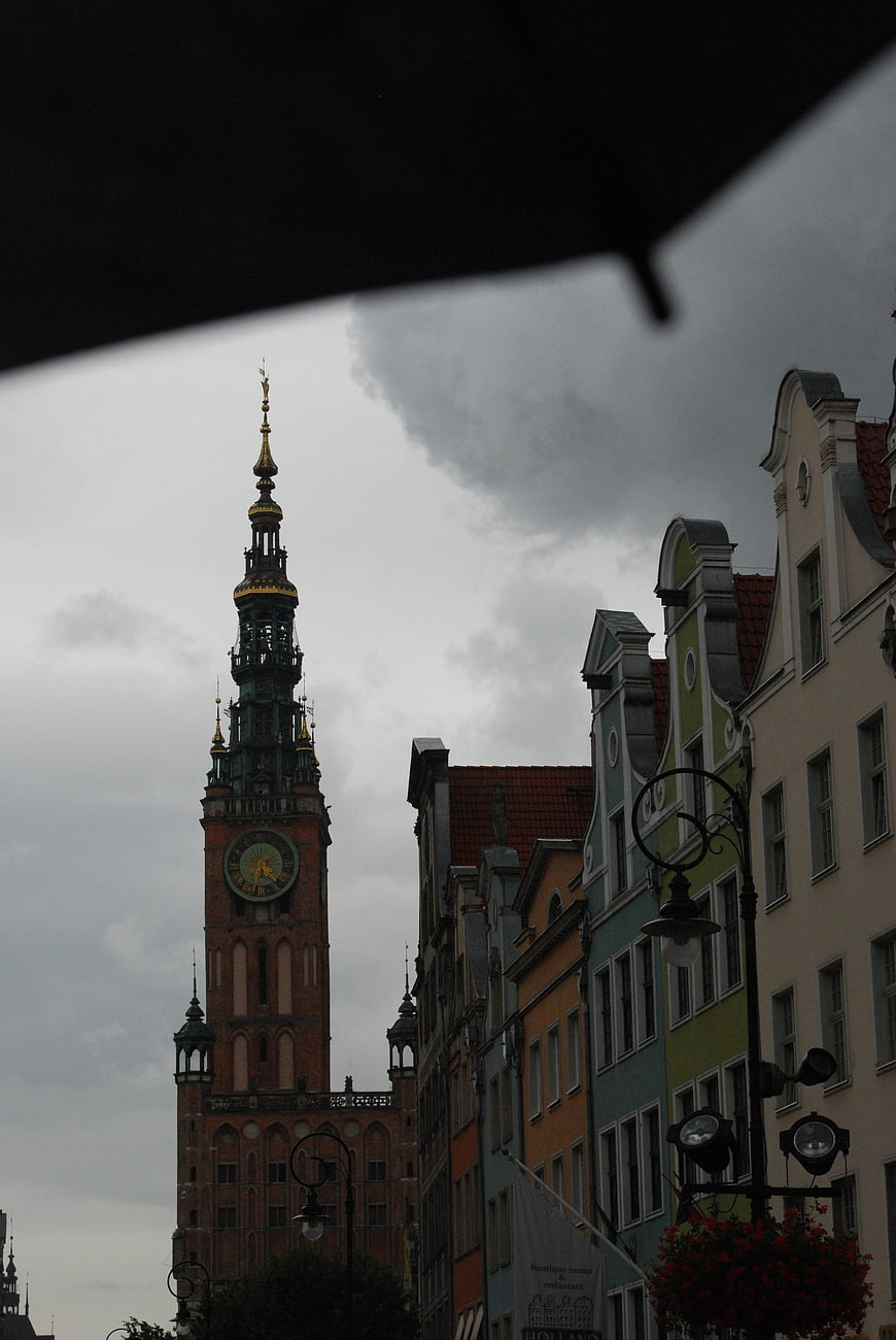 Gdansk Town Hall Tower and Colorful Buildings Under Rainy Sky