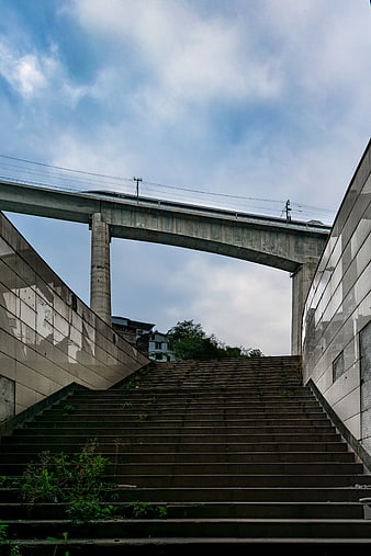 Concrete stairs leading up to high-speed rail overpass
