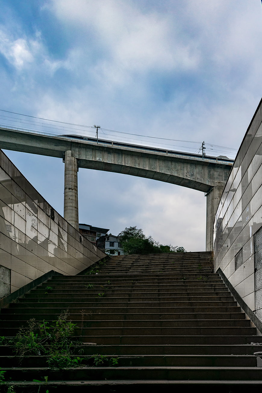 Concrete stairs leading up to high-speed rail overpass
