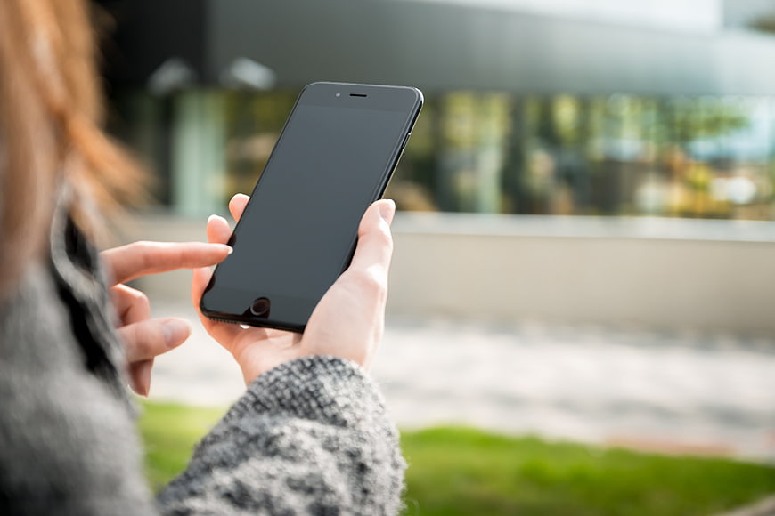 Woman using smartphone outdoors with blurred background