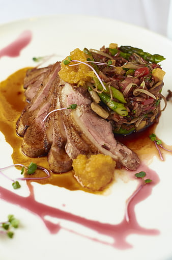 Gourmet sliced duck breast with wild rice and asparagus