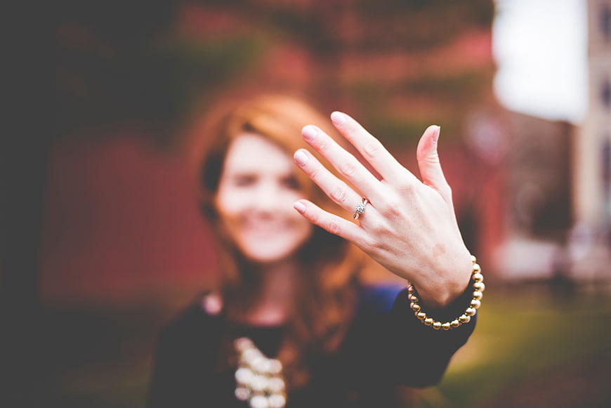 Woman showing engagement ring with blurred background