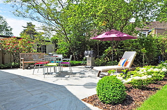 Sunny backyard patio with outdoor furniture and garden