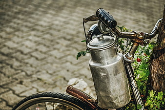 Vintage bicycle with rustic metal milk can attached to handlebars