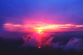 Vibrant purple and pink sunset above clouds aerial view