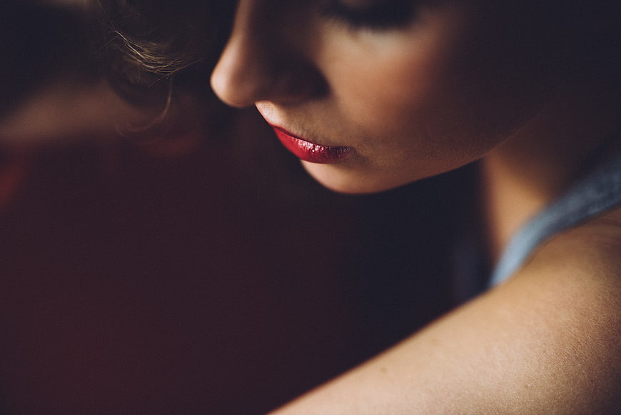 Close-up portrait of woman with red lipstick looking down
