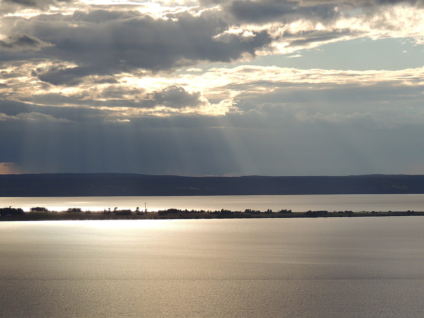 Dramatic Sun Rays Over Calm Lake and Distant Hills