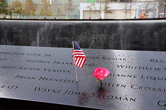 American flag and rose at 9/11 Memorial fountain