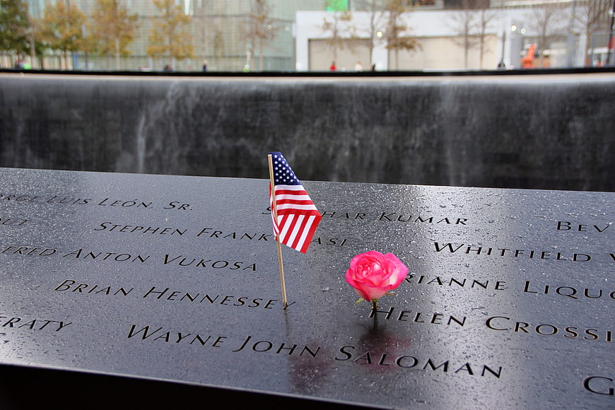 American flag and rose at 9/11 Memorial fountain