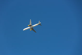 White Airplane Flying in Clear Blue Sky
