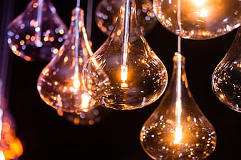 Glowing Vintage Light Bulbs Hanging Against Black Background