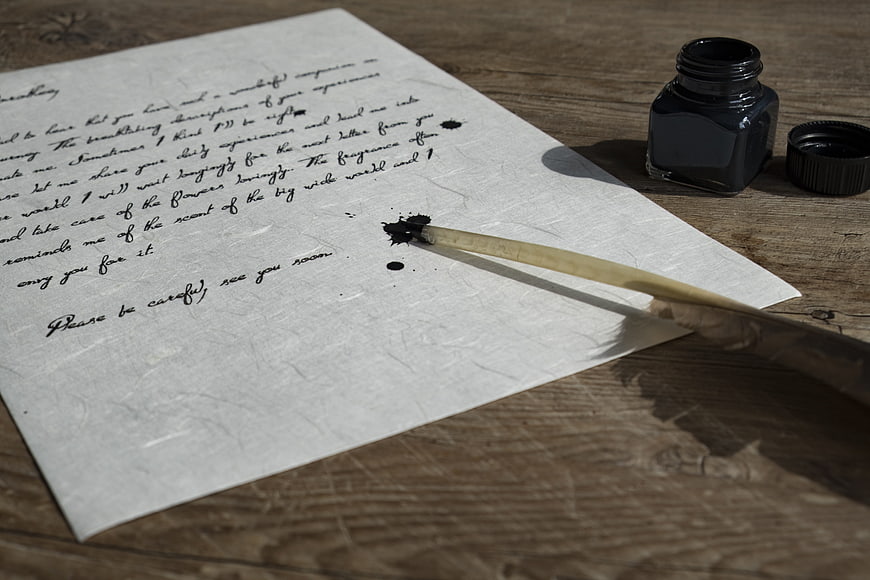 Vintage handwritten letter with quill pen and ink on wood
