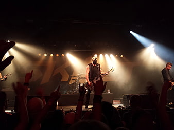 Rock band performing live on stage with energetic crowd