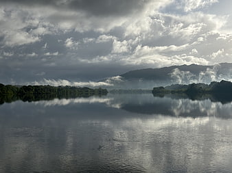 Serene Lake Landscape with Cloud Reflections and Misty Mountains