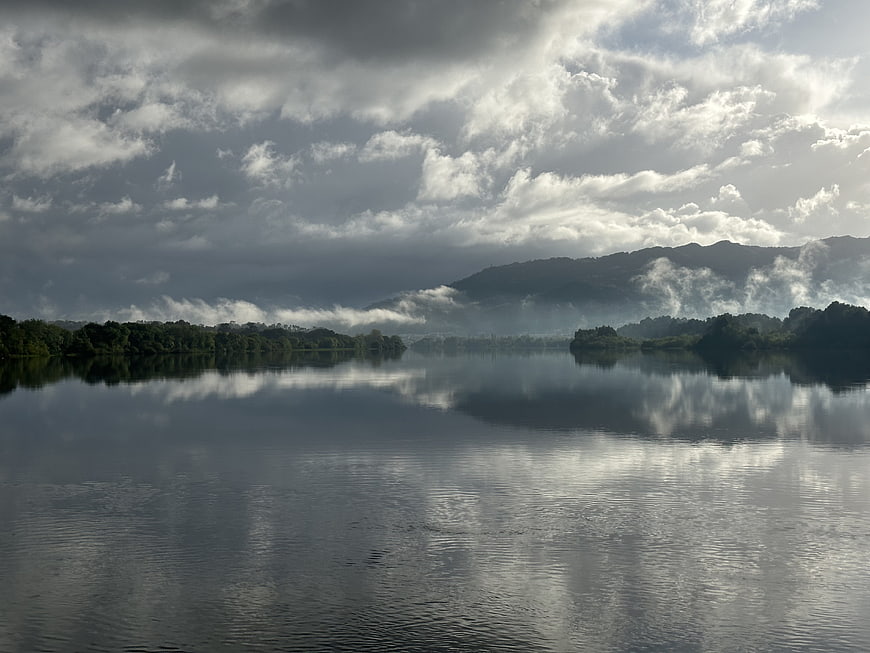 Serene Lake Landscape with Cloud Reflections and Misty Mountains