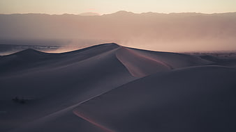 Aerial View of Sand Dunes at Sunset with Distant Mountains